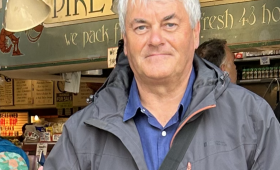 photo of a man standing in front of a shop.