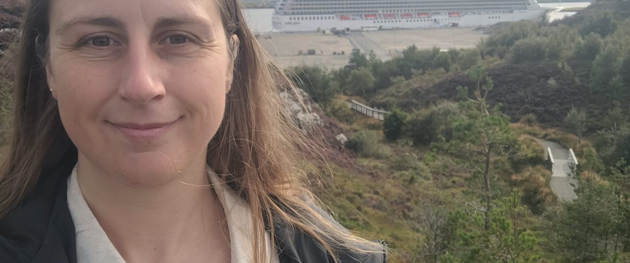 woman smiling with cruise ship in the background